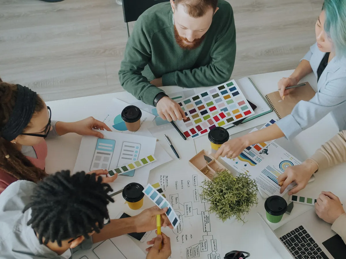 Creative team reviewing color swatches, printed mockups and a brand map on a shared table