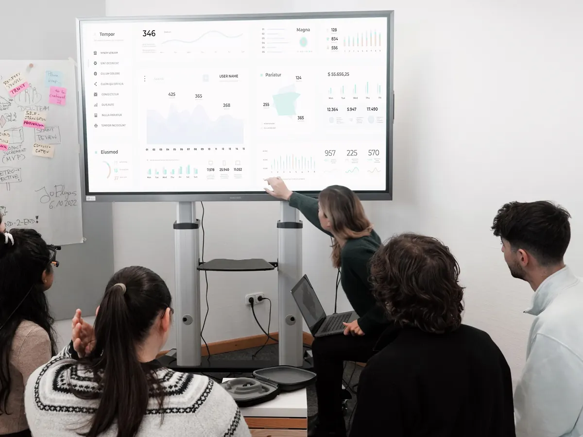 Marketing team reviewing a live analytics dashboard on a large screen during a meeting